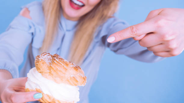 istock Funny woman holds cream puff cake 934283584