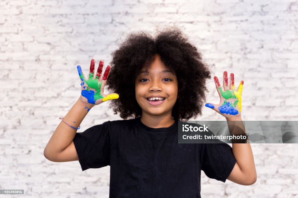 Mains s’afro-américains kid ludique et créative sale avec beaucoup de couleurs - en fond de briques blanches. - Photo de Enfant libre de droits