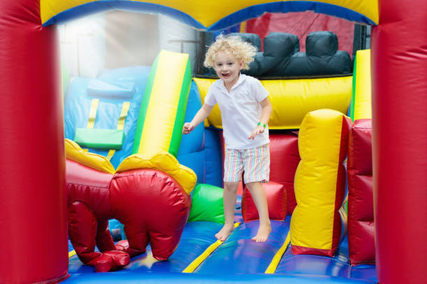 istock Child jumping on playground trampoline. Kids jump. 934292764