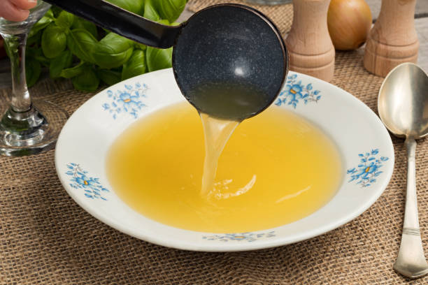 istock Pouring chicken bone broth into a soup plate with a ladle 934292808