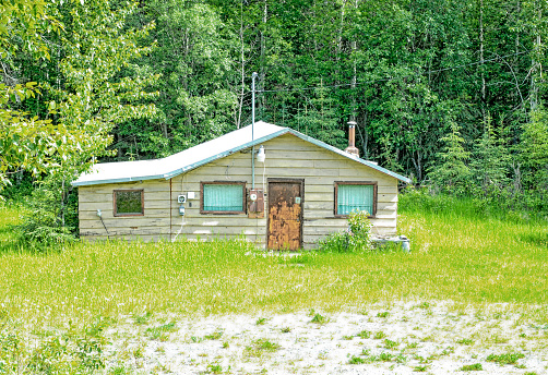 Abandoned hunter cabin located in a field in Alaska.