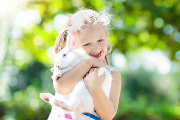istock Child with rabbit. Easter bunny. Kids and pets. 934298380