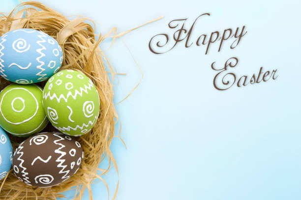 istock Easter card. Painted Easter eggs in nest on pale blue background 934303872
