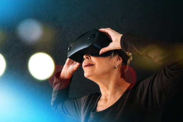 istock An elderly woman in virtual reality glasses. An elderly person using modern technology. 934307236