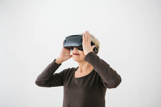 istock An elderly woman in virtual reality glasses. An elderly person using modern technology. 934307514