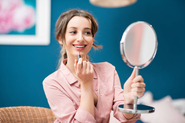 istock Woman applying a lipstick at home 934313452