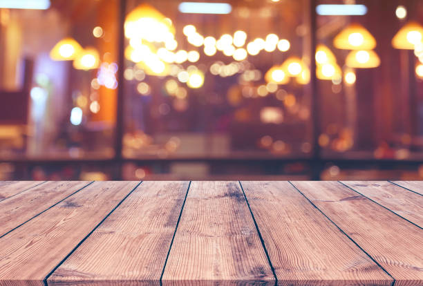 istock Wood table with blur light bokeh in night restaurant 934313742