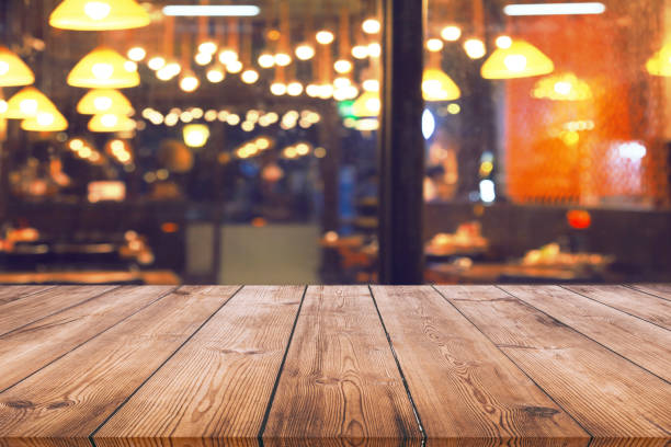istock Wood table with blur light bokeh in night restaurant 934316040