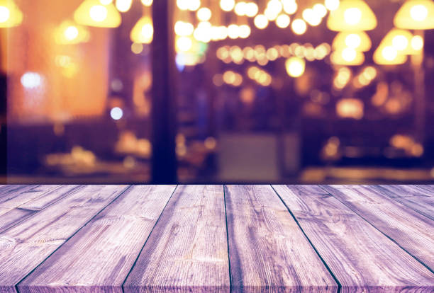 istock Wood table with blur light bokeh in night restaurant 934316070