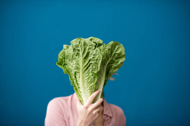 istock Woman with lettuce on the blue background 934319122