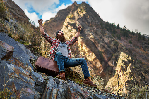 screaming bearded hipster gloating over mountain climb all by himself