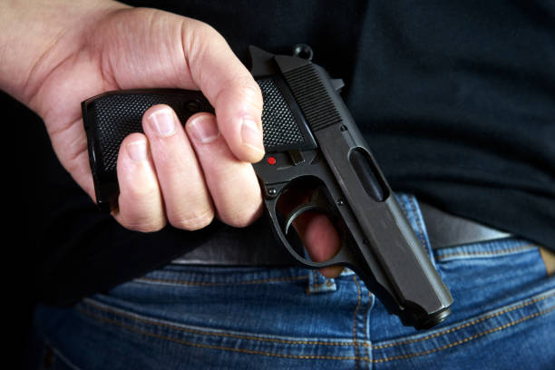 istock Hidden gun in hands back side to man in blue jeans 934337094