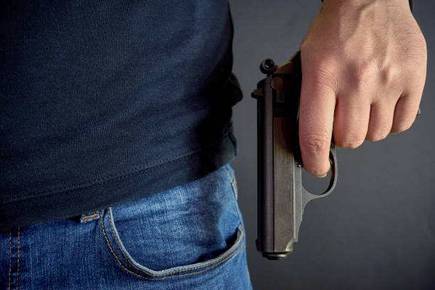 istock Killer holding a gun side him, robbery, murder, crime 934337126