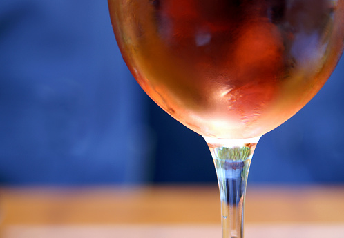 Splash of orange liquid in transparent glass cut glass on orange background