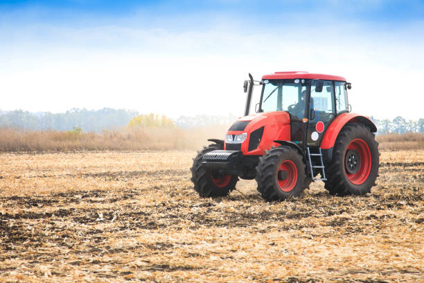 Modern red tractor in the field. - fotografia de stock