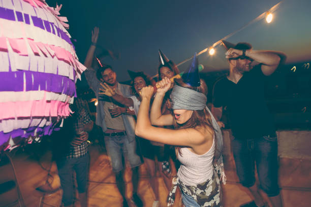cumpleaños piñata golpear - birthday party adult women fotografías e imágenes de stock
