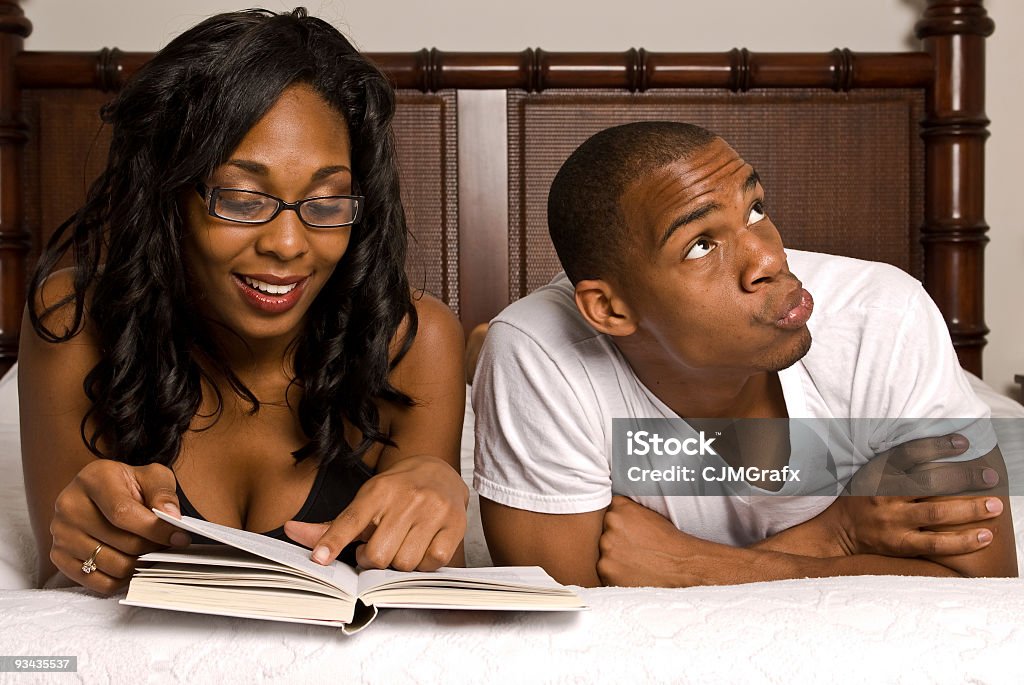 couple afro-américain au lit un livre de lecture - Photo de Adulte libre de droits