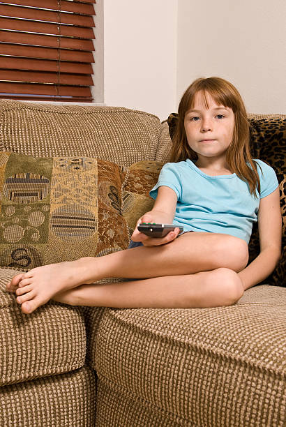 Young female child watching television stock photo