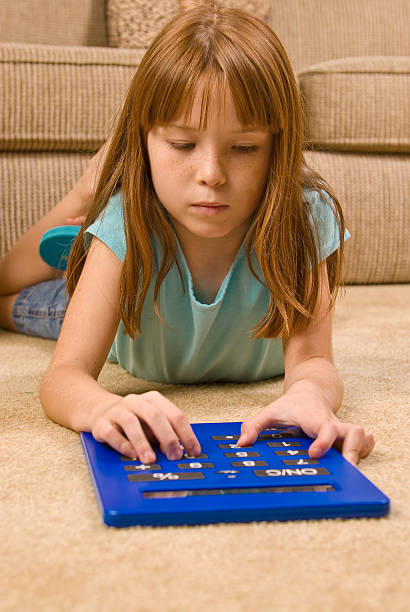 Young female child works on an oversized calculator stock photo