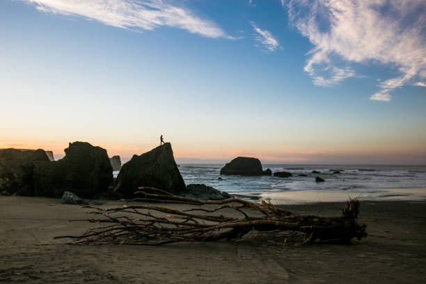 istock Silhouette of man on rock at sunset on Oregon Coast 934366826