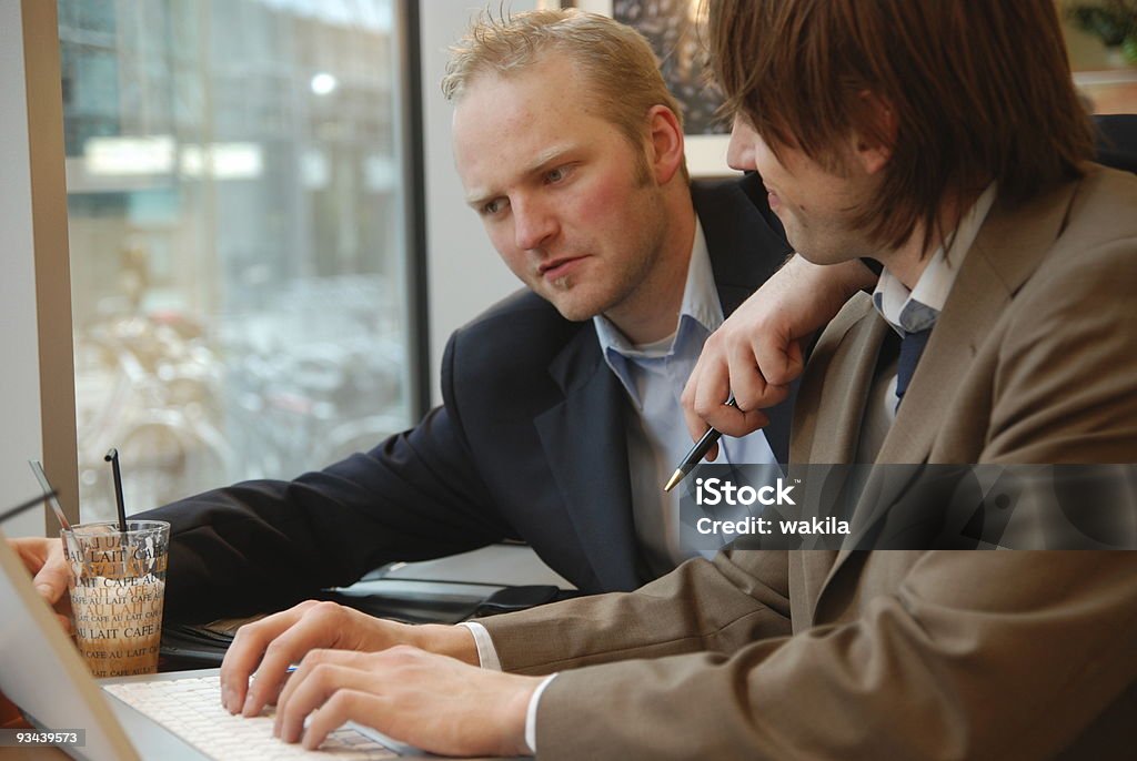Командная работа двух молодых мужчин людей, работающих вместе в офисе - Стоковые фото Беспроводная технология роялти-фри