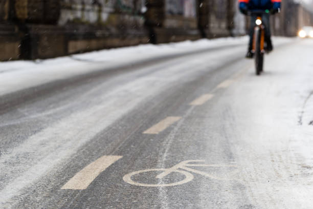 istock Snow-capped bike path and a cyclist 934400028