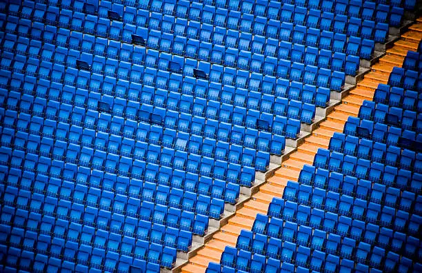 Blue bleachers and orange steps in Madrid stadium.