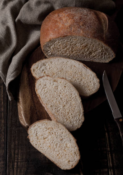 istock Freshly baked bread loaf with pieces on wood board 934441952