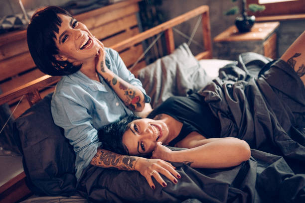 istock Two lesbian girls laying on bed and smiling 934475314