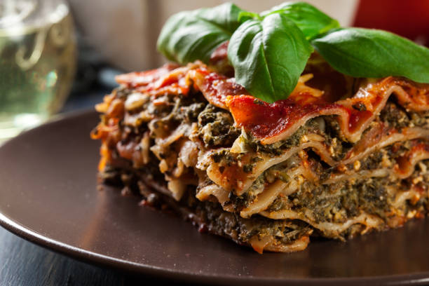 Piece of tasty hot lasagna with spinach on a plate stock photo