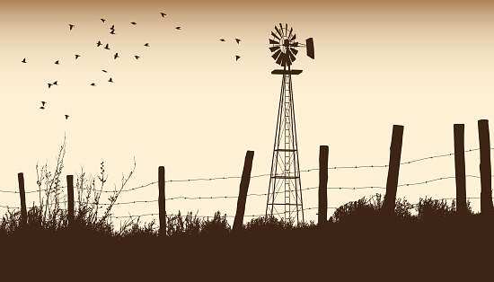 Vintage rural scenery with windmill and barbwire fence in sepia tone
