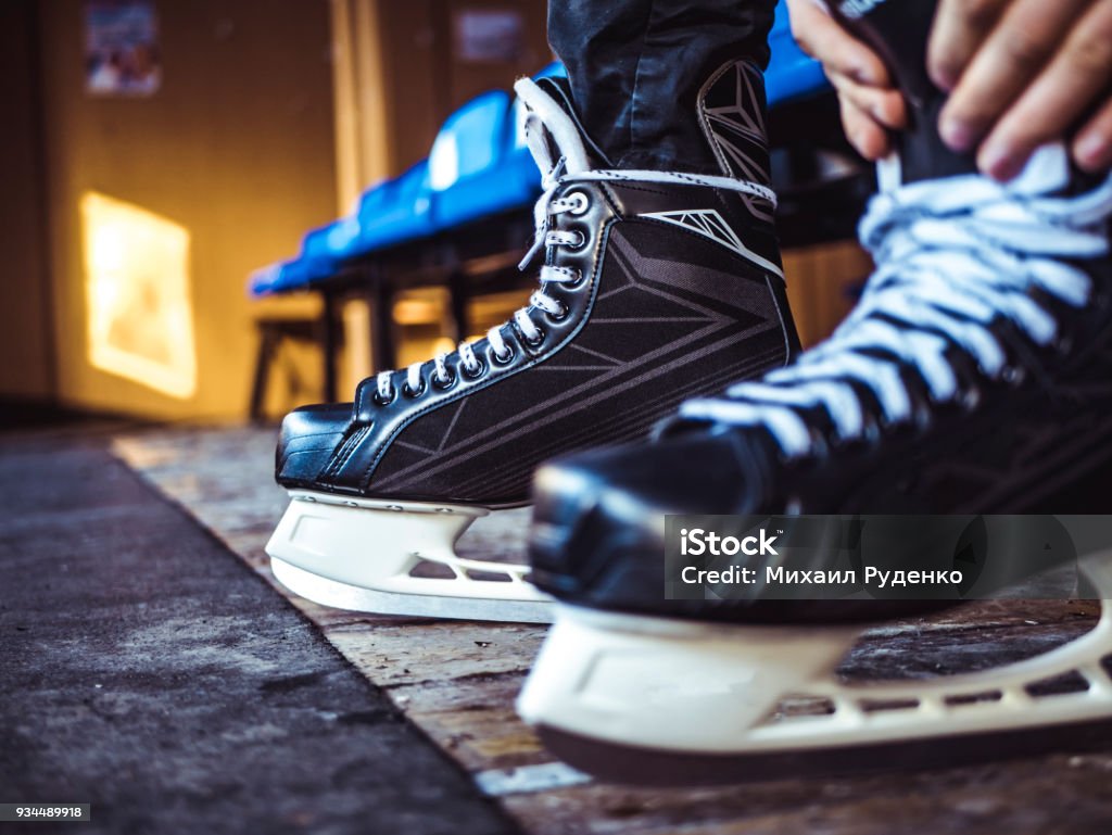 close up shot of hand tie shoelaces of ice hockey skates in locker room Ice Skate Stock Photo