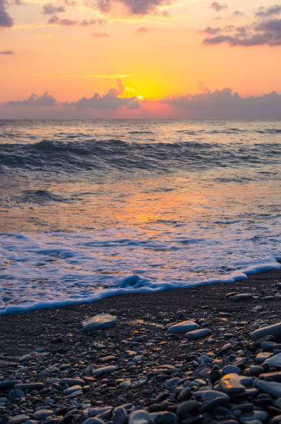 istock Amazing sea sunset on the pebble beach, the sun, waves, clouds 934491632