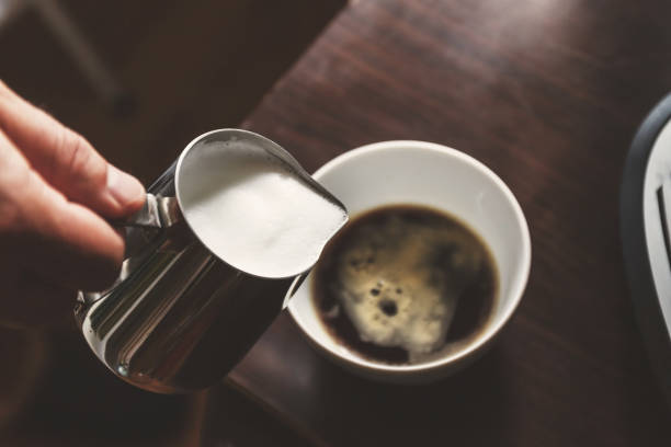 istock man pouring into a cup of coffee with milk 934492212
