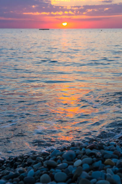 istock Amazing sea sunset on the pebble beach, the sun, waves, clouds 934501538