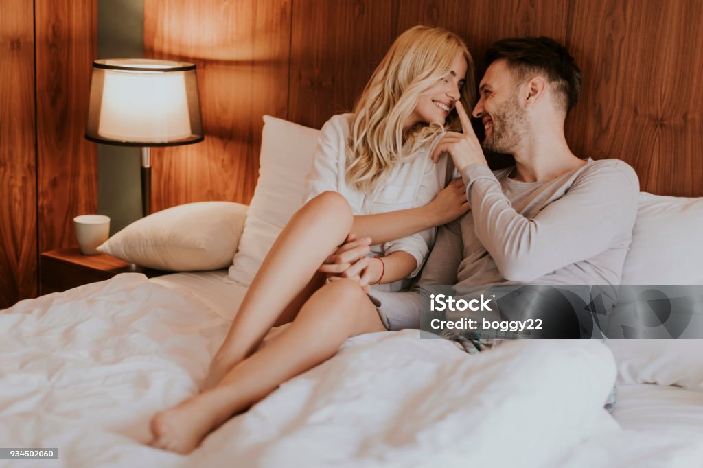 Romántica pareja en el amor acostado en la cama juntos - Foto de stock de Pareja joven libre de derechos