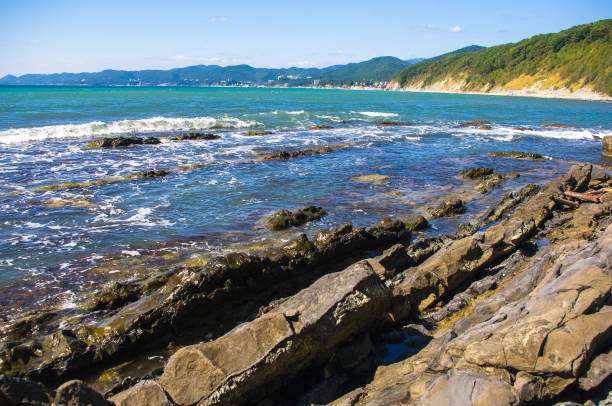 istock rocky sea shore with pebble beach, waves with foam 934506536