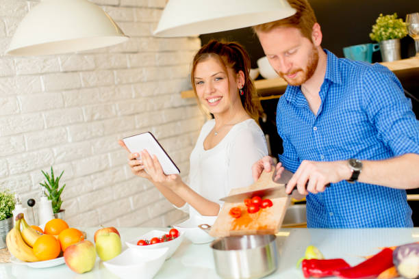 istock Young couple have fun in modern kitchen indoor while preparing vegetables food for lunch 934506604