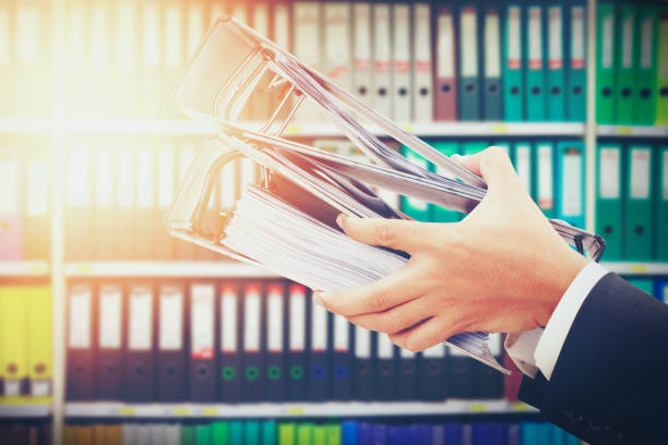 istock close up of hand holding file binder on office shelves background 934528202