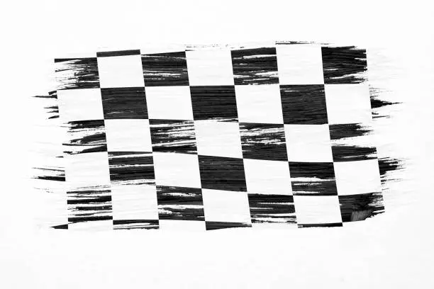 Photo of Closeup of art brush watercolor painting checkered black and white racing flag blown in the wind isolated on white.