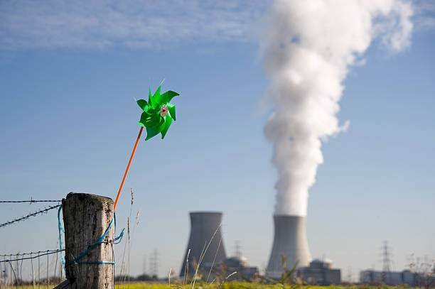 vento contro l'energia nucleare - wind power toy symbol cooling tower foto e immagini stock