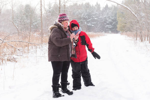 istock Mom and young son looking at smart phone on winter day 934566464