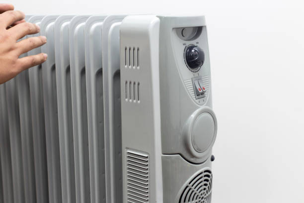 istock man lays his hands for oil heater for getting warm on white background. 934577248