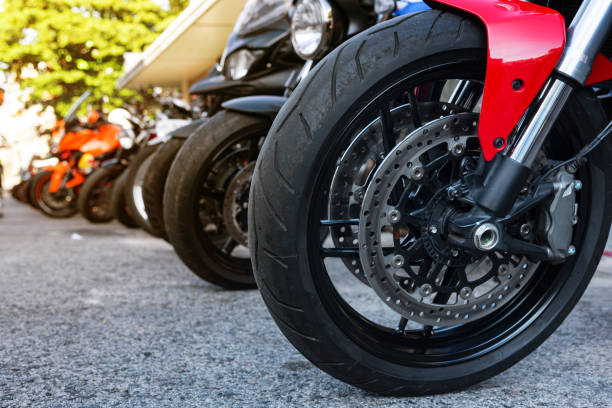 Motorcycle front wheel with red mud guard and twin disc brake.