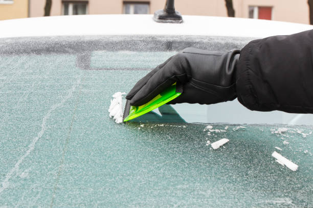 istock Hand in glove scraping ice from car windscreen 934587874