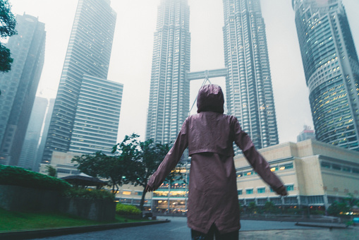 Young Caucasian woman  looking at   Petronas tower in fog