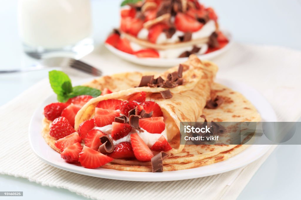 Crepes stuffed with curd cheese, strawberries and chocolate Crepes with curd cheese and strawberries sprinkled with chocolate shavings Chocolate Shaving Stock Photo