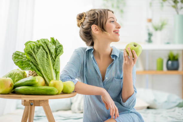 donna con cibo verde sano a casa - apple women green eating foto e immagini stock