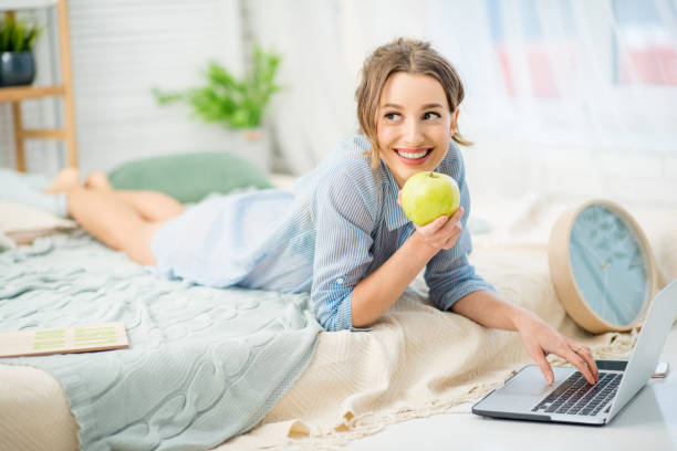 ritratto donna in camera da letto - apple women green eating foto e immagini stock