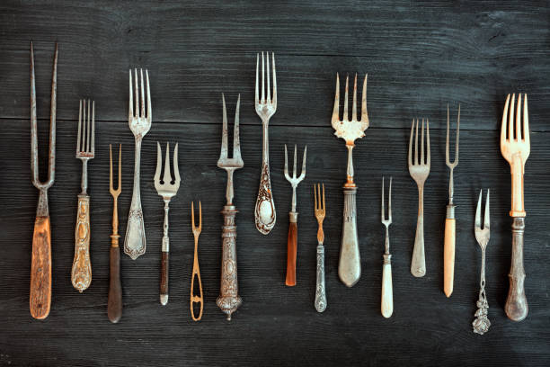 Top view on various forks, old utensils. Flat lay on rustic  dark wooden background. Antique kitchenware background stock photo